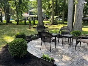 Hardscaping paver patio with patio furniture and mulch around it