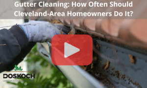 Person cleaning gutters with gloves. Red play buttom overlay with words: Gutter Cleaning: How Often Should Cleveland-Area Homeowners Do It?