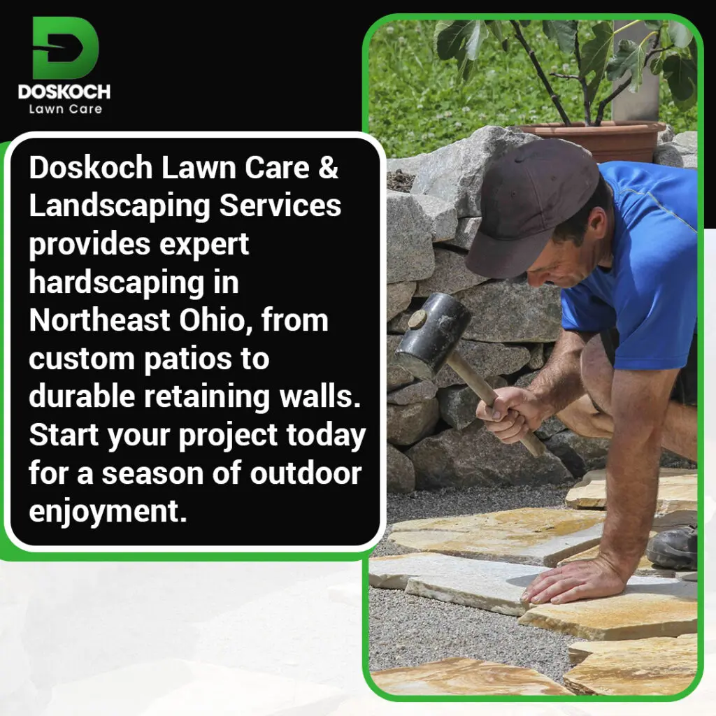 Worker installing natural stone patio and retaining wall for outdoor landscaping project