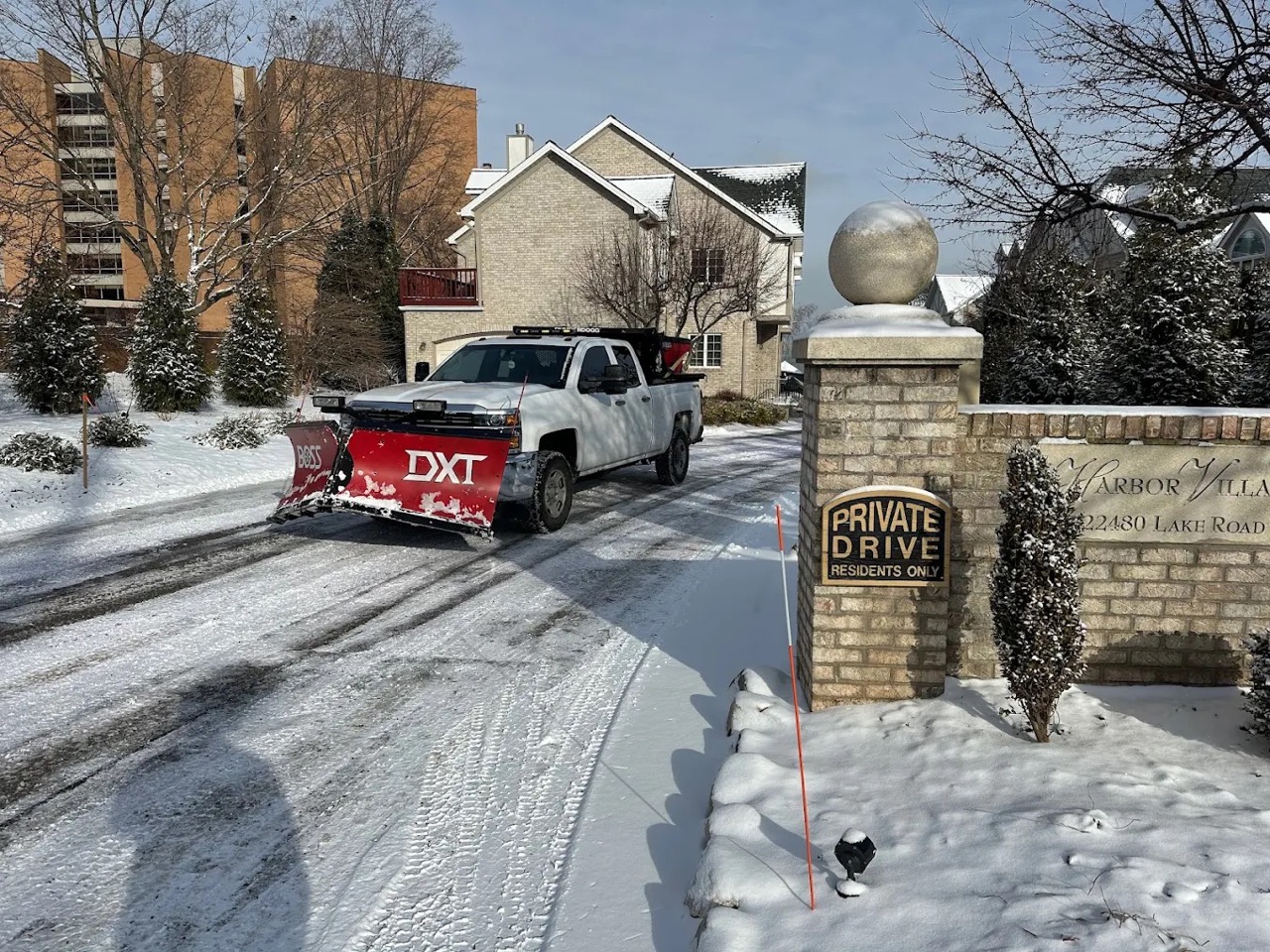 Doskoch pickup truck with snow plow clearing a private residential drive after fresh snowfall at Arbor Villas