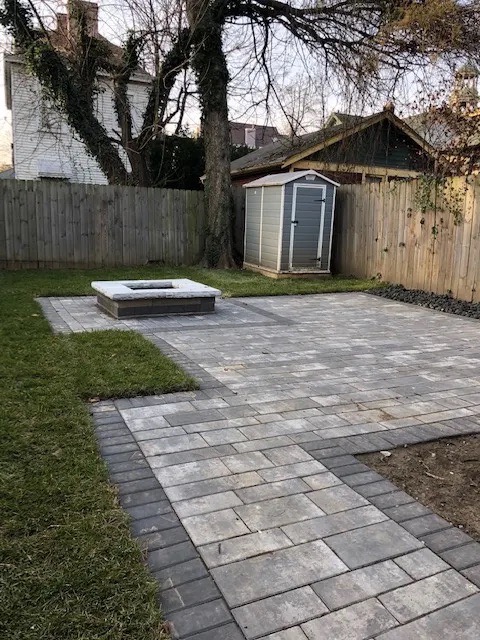 Finished gray paver patio and walkway installed by Doskoch Landscaping in a residential backyard