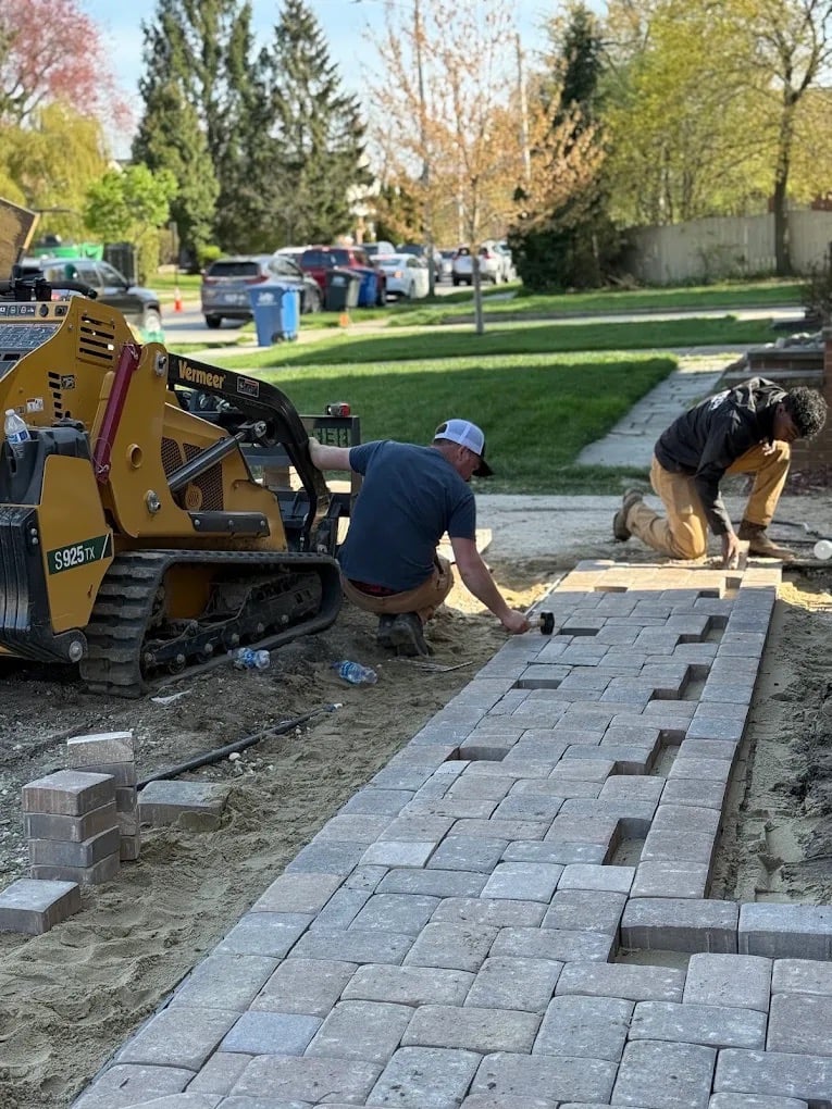 Doskoch Landscaping crew installing a gray paver walkway at a Northeast Ohio home