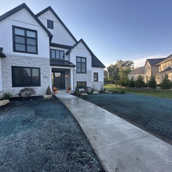 New Lawn Installation Newly installed front yard landscaping with fresh lawn treatment, clean edging, and dark mulch beds surrounding a modern white home.